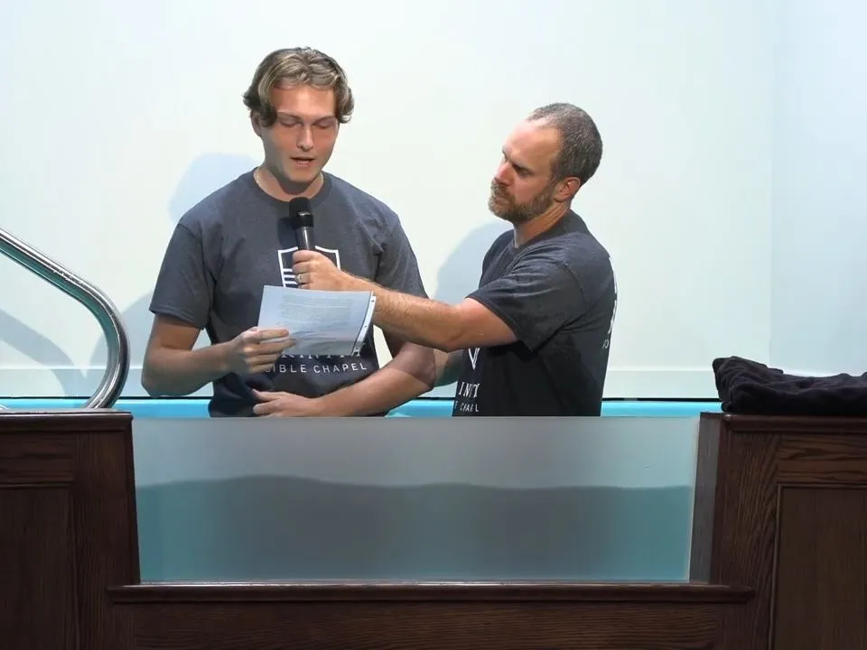 A member sharing his testimony before baptism at Trinity Bible Chapel