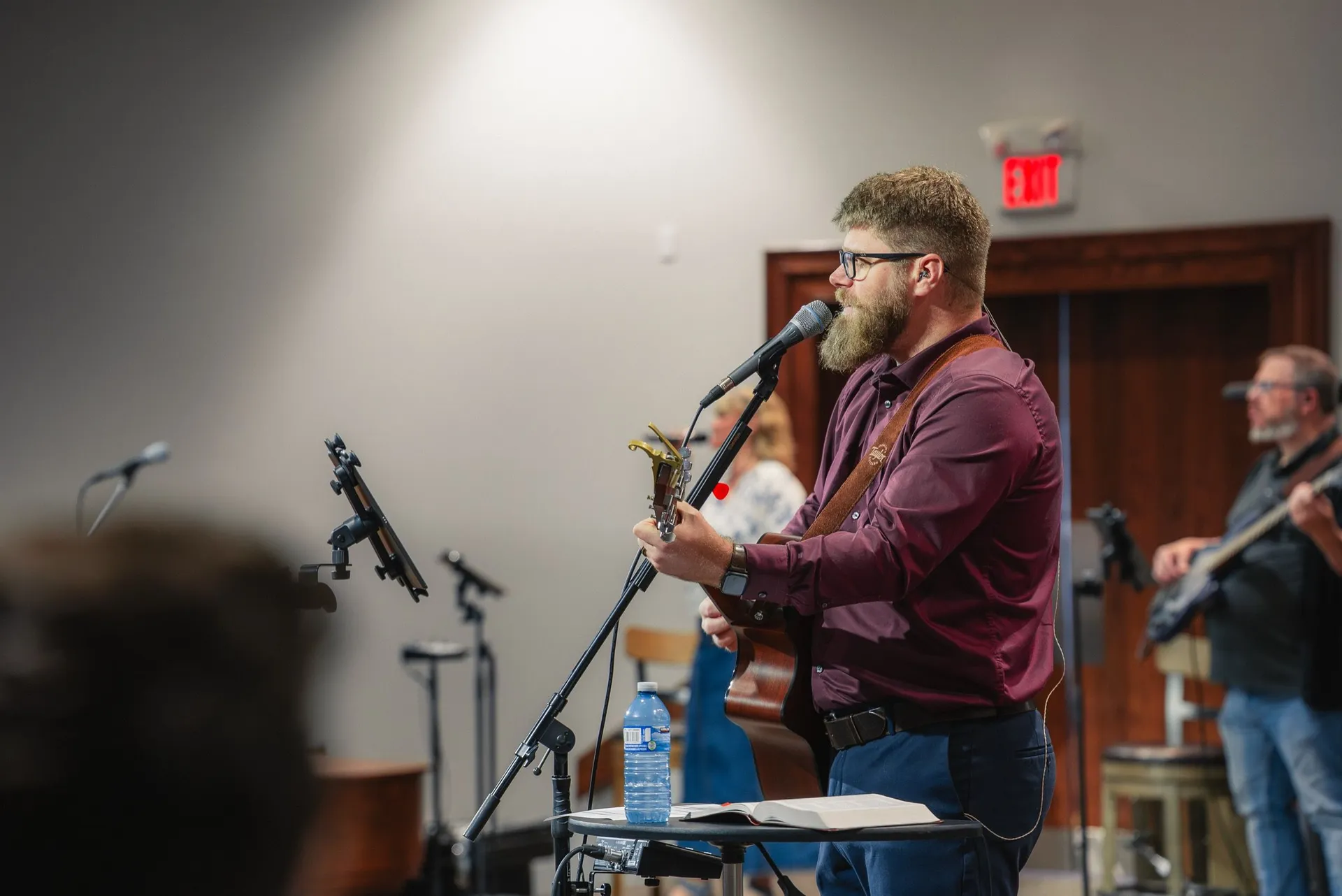A worship leader singing and playing guitar on Sunday morning